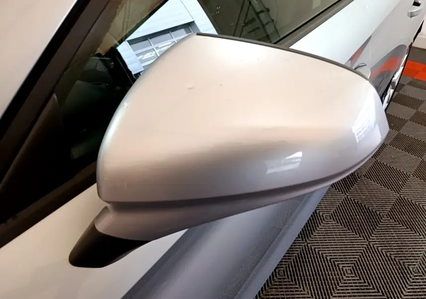 Gros plan sur le rétroviseur côté conducteur gris clair du SEAT Leon 2022, avec partie de la portière visible.