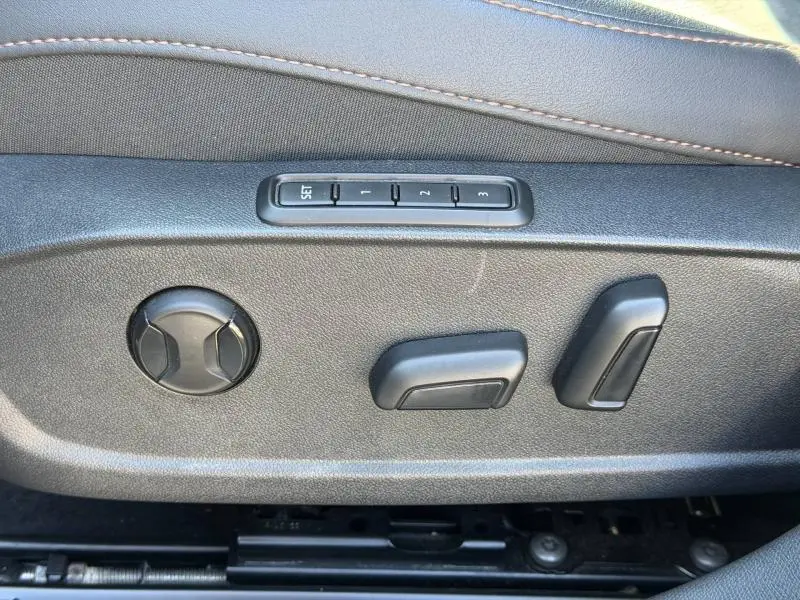 Gros plan sur les commandes de réglage électrique du siège conducteur du CUPRA Formentor 1.5 eTSI Hybrid noir Minuit.