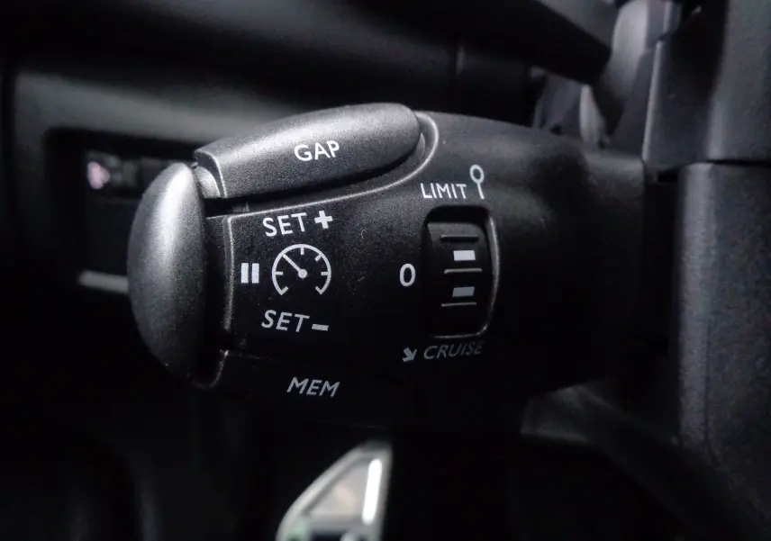 Gros plan sur la commande de régulateur de vitesse du Citroën C5 Aircross noir métal, version essence 2022.