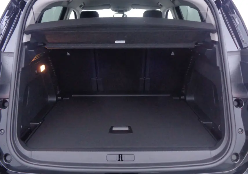 Coffre ouvert d'un Citroën C5 Aircross noir métal 2022, vue arrière montrant un espace de chargement spacieux et bien éclairé.