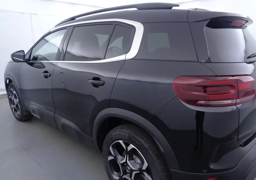 Vue 3/4 arrière droite du Citroën C5 Aircross noir métal avec jantes biton et contours de vitres chromés.