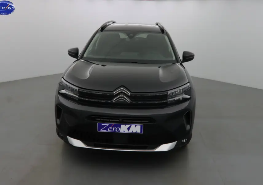 Vue frontale d'un Citroën C5 Aircross noir métal avec calandre distinctive et plaques "Zero KM" dans un studio.