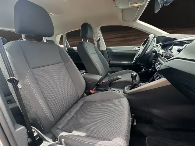 Vue intérieure côté conducteur de la Volkswagen Polo VI Lounge Business 2021 avec sièges tissu noir et tableau de bord moderne.