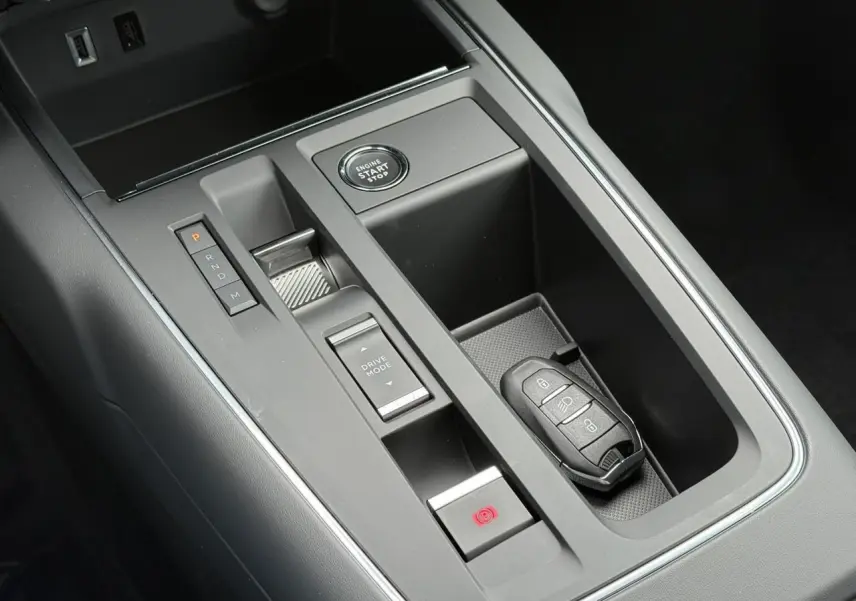 Gros plan sur la console centrale noire du Citroën C5 Aircross Hybrid avec bouton start/stop et clé mains-libres.