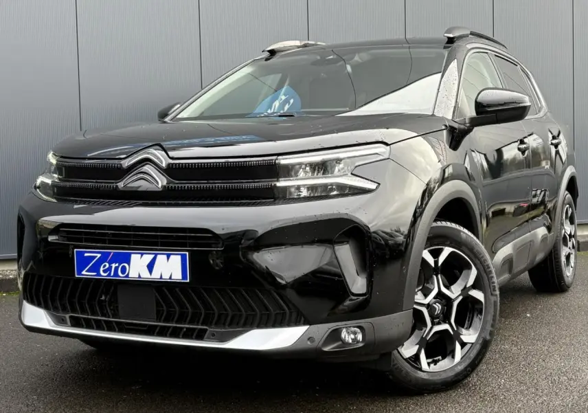 Citroën C5 Aircross Hybrid noir Perla vu 3/4 avant droit avec jantes alliage bi-ton et barres de toit noires.