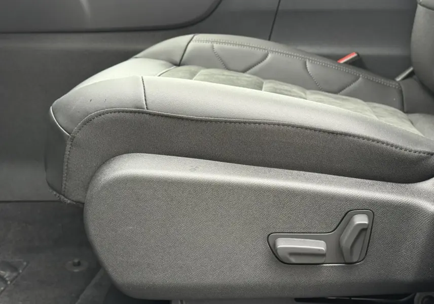 Détail du siège conducteur noir en Alcantara et tissu effet cuir du Citroën C5 Aircross Hybrid 2025, côté gauche avec commandes électriques.