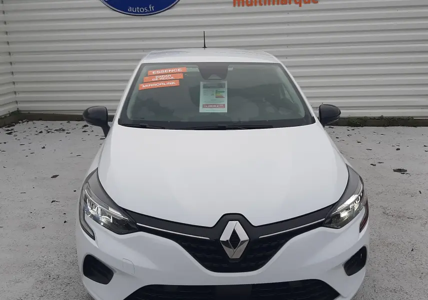 Vue avant d'une Renault Clio V blanche 2022 avec plaques "OCCASION" et autocollants sur le pare-brise.
