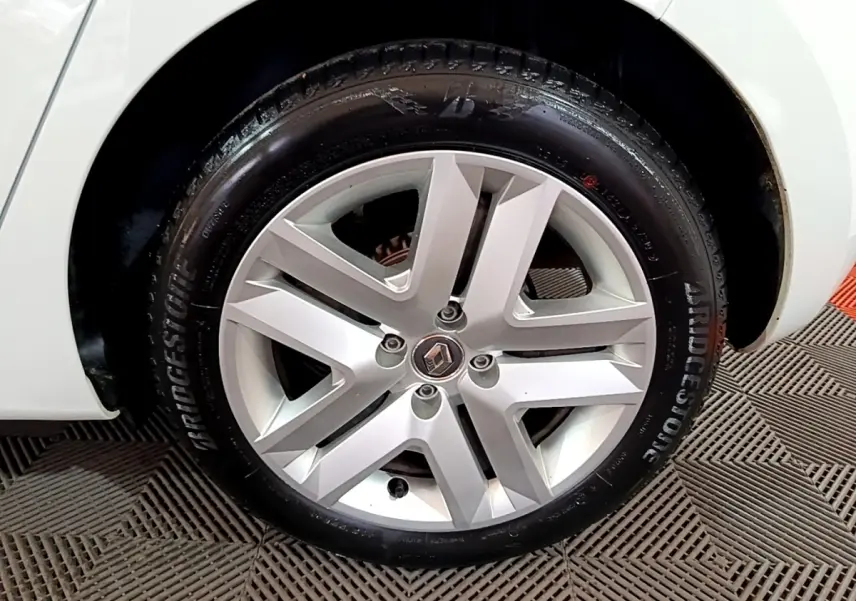 Gros plan sur la roue avant droite de la Renault Clio Business blanche avec jante alliage et pneu Bridgestone.