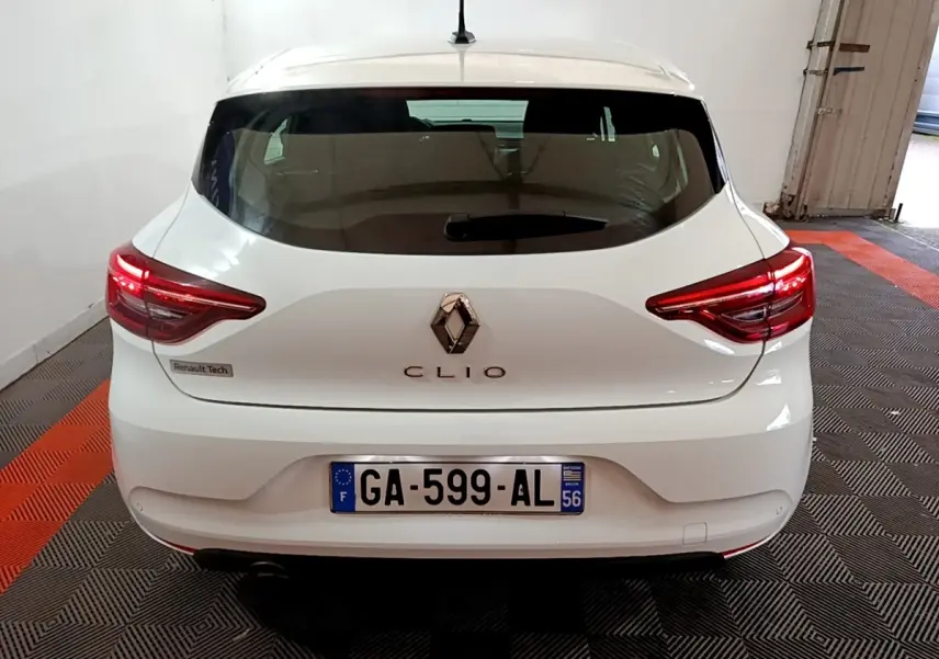 Vue arrière d'une Renault Clio blanche 2021 avec feux LED allumés dans un garage fermé.