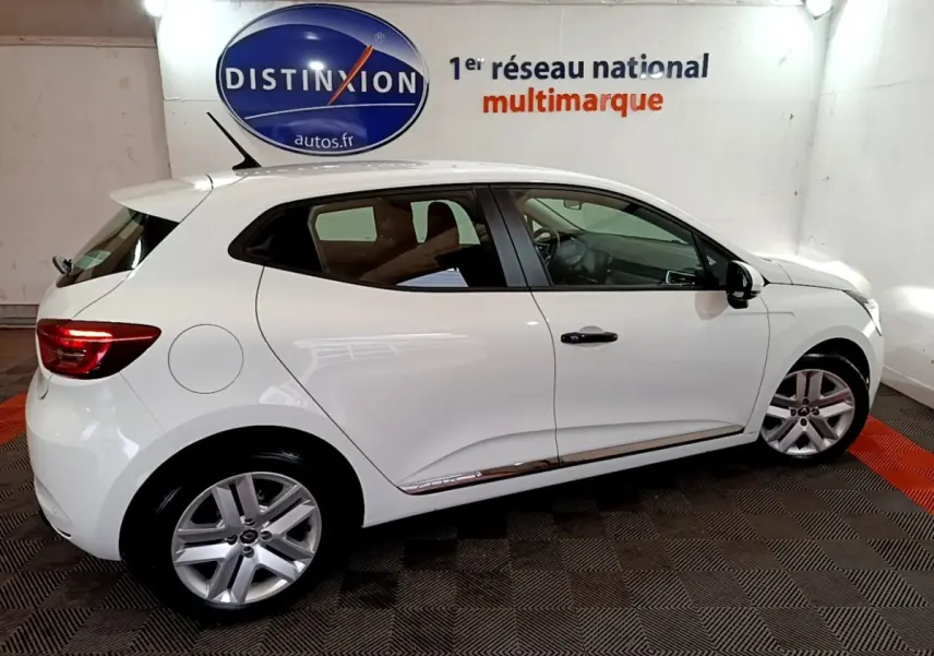 Renault Clio Business blanc vue de profil côté gauche, en intérieur avec jantes alliage et feux arrière allumés.