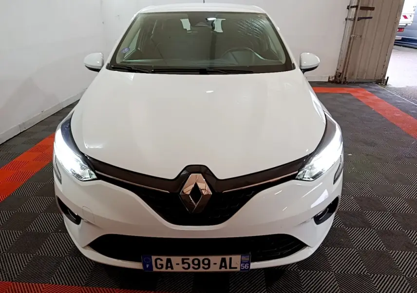 Vue frontale d'une Renault Clio Business blanche 2021 avec phares LED allumés dans un garage.