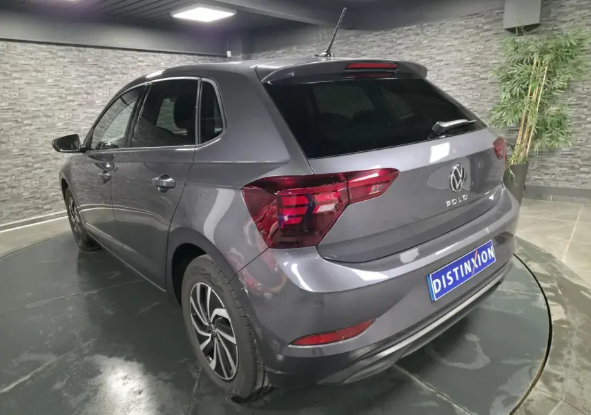 Vue 3/4 arrière gauche d'une Volkswagen Polo gris métallisé avec jantes alliage et vitres arrière surteintées.