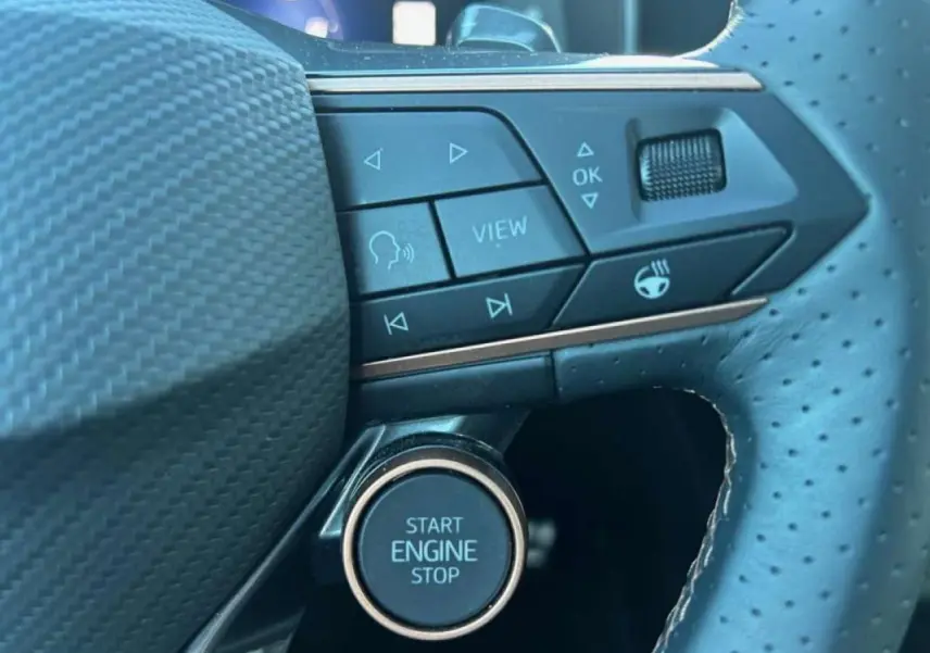 Gros plan sur le volant perforé noir du CUPRA Formentor blanc 2025, avec boutons multifonctions et bouton start/stop.