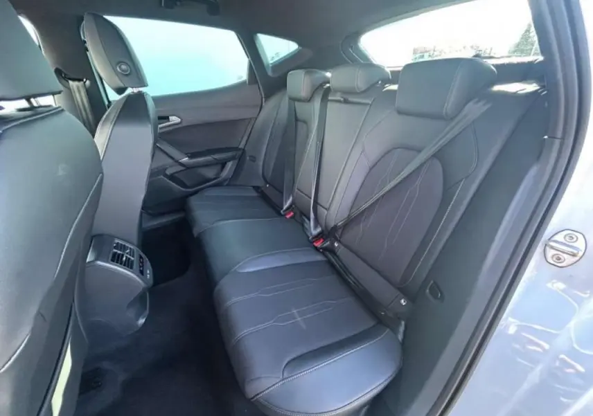 Vue intérieure côté droit des sièges arrière en cuir noir du CUPRA Formentor blanc 2025, avec ceinture de sécurité visible.