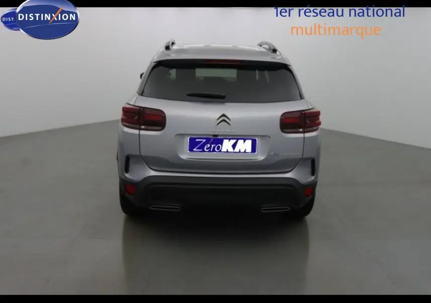 Vue arrière d'un Citroën C5 Aircross 2022 gris Artense métallisé avec feux arrière foncés et double sortie d'échappement intégrée.