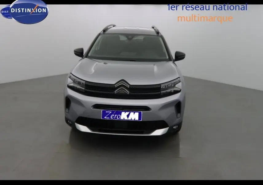 Vue frontale d'un Citroën C5 Aircross gris Artense métal avec calandre noire et plaques d'immatriculation bleues Zero KM.