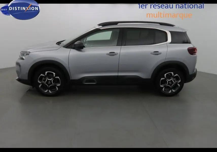 Profil côté gauche du Citroën C5 Aircross gris Artense métal avec jantes bi-ton et barres de toit noires.