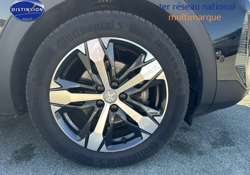 Gros plan sur la jante alu noire et argentée du côté avant droit d'un Peugeot 3008 noir métal 2022.