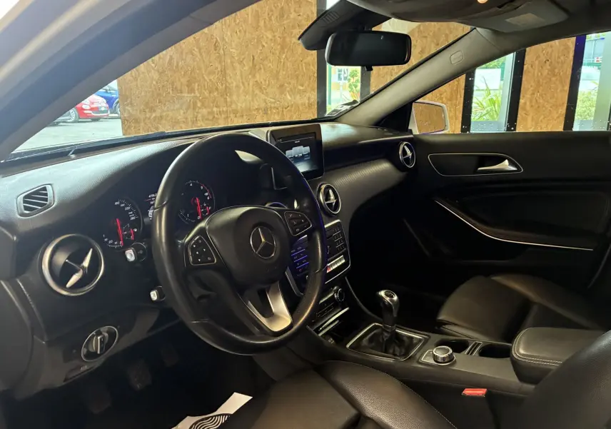 Intérieur noir de la Mercedes Classe A 200D 2016, vue côté conducteur avec volant multifonction et boîte manuelle.