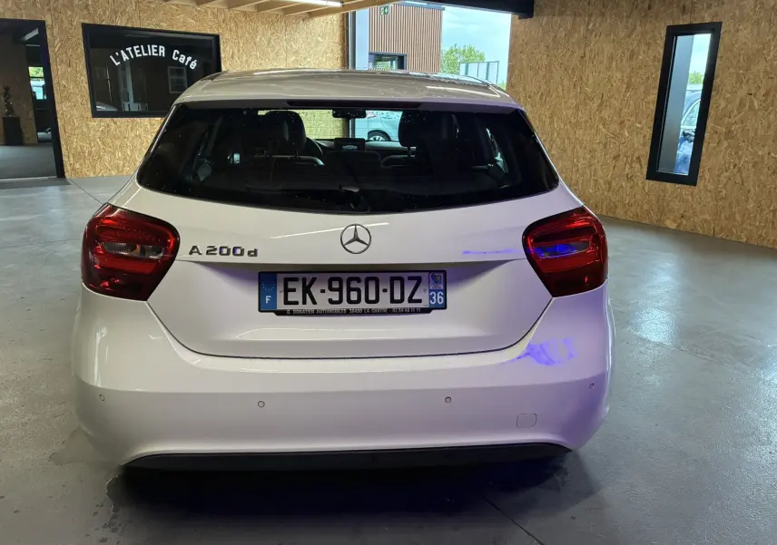 Vue arrière d'une Mercedes Classe A 200d blanche de 2016, avec plaque d'immatriculation française visible en intérieur.