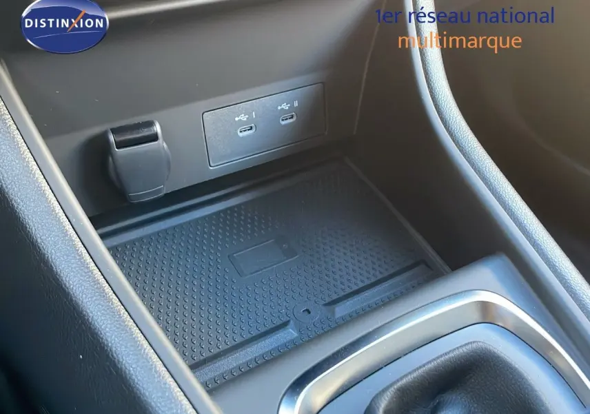 Gros plan sur la console centrale avec prise USB double et espace de rangement du Renault Captur bleu Iron Metal toit noir.