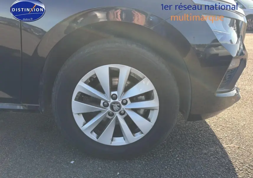 Gros plan sur la roue avant droite et partie du pare-chocs avant d’un Skoda Kamiq noir avec jante alu.