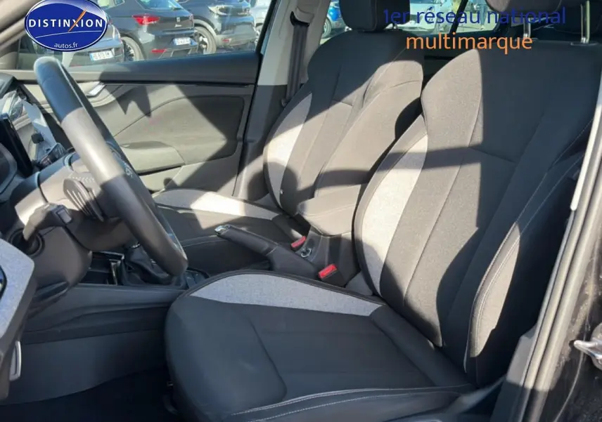 Vue intérieure côté conducteur du Skoda Kamiq noir 2025, mettant en valeur les sièges bicolores et le volant multifonction cuir.