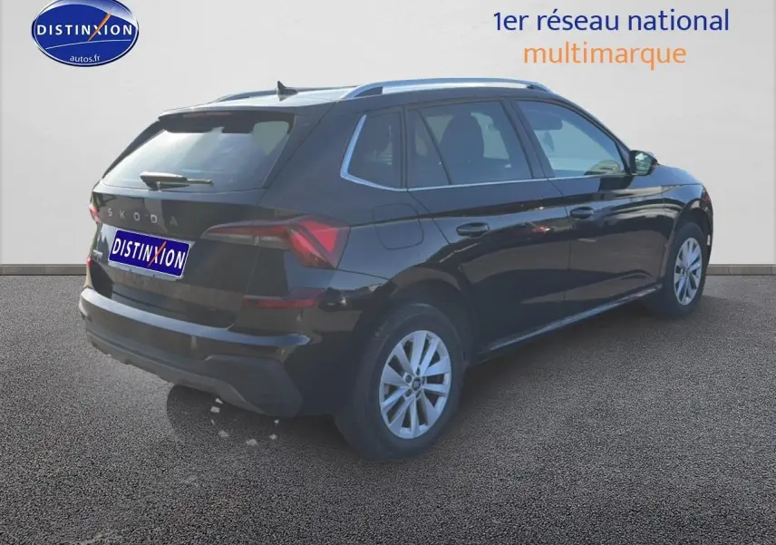 Vue 3/4 arrière droite d'un Skoda Kamiq noir 2025 avec jantes alu et barres de toit visibles.
