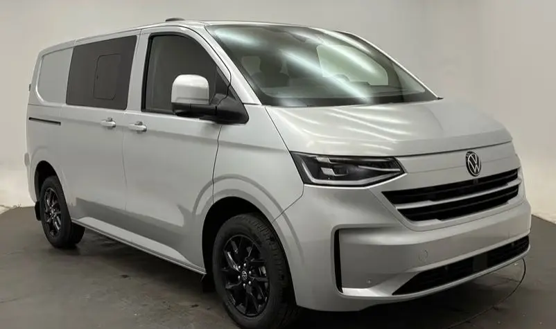 Vue 3/4 avant droit du Volkswagen Transporter ProCab gris clair avec jantes noires et phares LED.