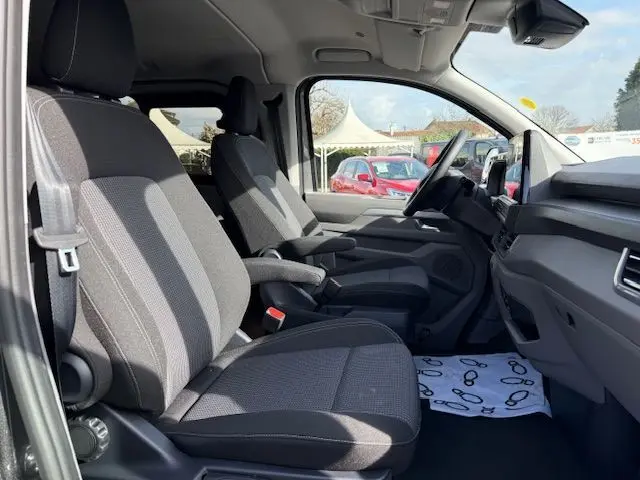 Vue intérieure côté droit du Volkswagen Transporter T7 ProCab 2026 en graphite dust, montrant les sièges avant et le tableau de bord.