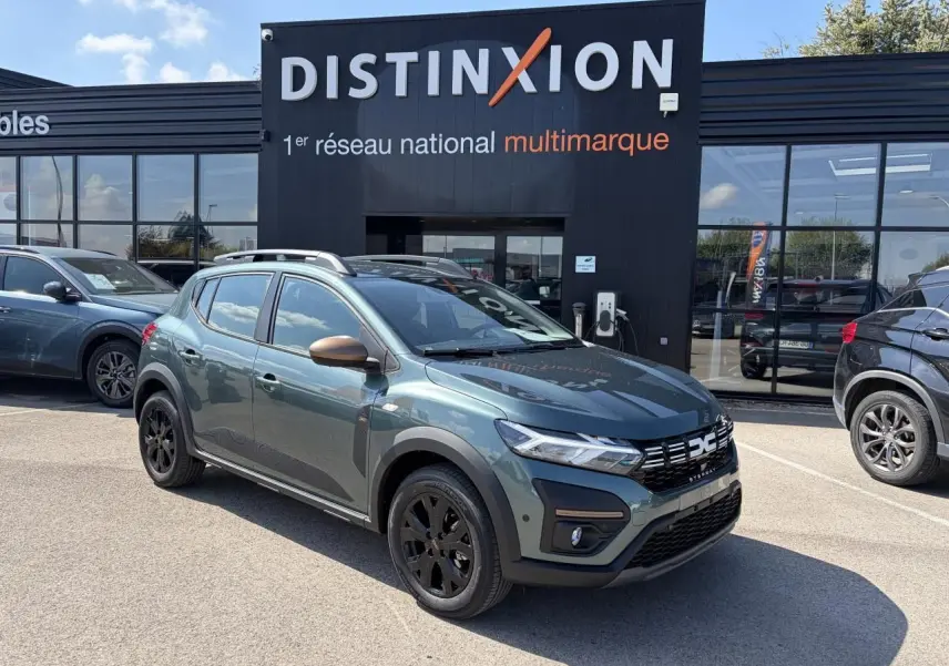 Vue 3/4 avant gauche d'une Dacia Sandero III Stepway 2025 vert cèdre avec jantes noires et coques de rétroviseur cuivrées.
