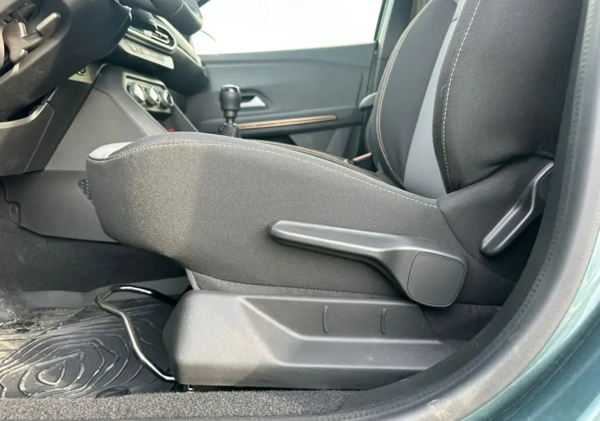 Vue intérieure côté gauche du siège avant tissu noir avec réglage manuel sur Dacia Sandero III Stepway vert cèdre.