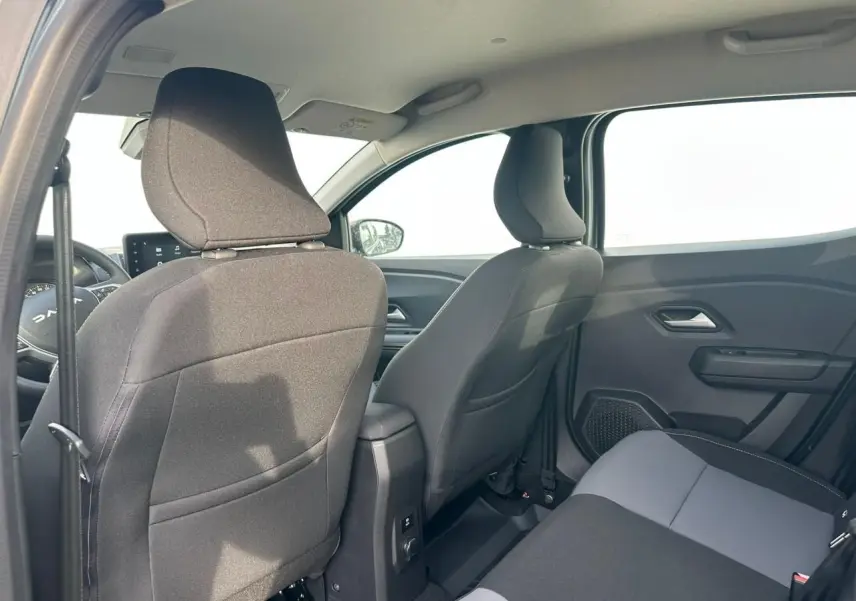 Vue intérieure arrière côté droit de la Dacia Sandero III Stepway 2025 avec sièges tissu gris et noir.