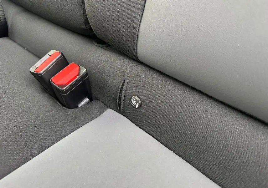 Détail de la banquette arrière noire avec ceintures rouges et logo Isofix sur la DACIA Sandero III Stepway.