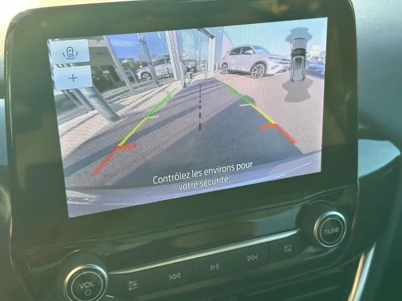 Vue écran caméra de recul du Ford Puma 2024 gris Solar métallisé, montrant l’arrière avec lignes de guidage colorées.