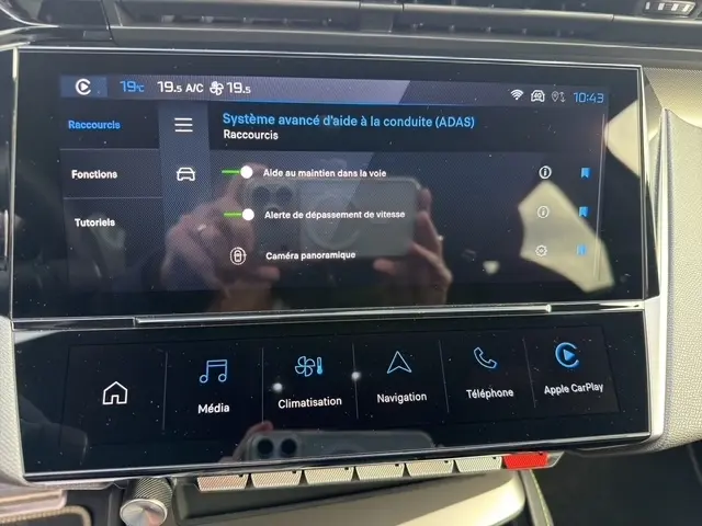 Écran tactile central du Peugeot 408 Hybrid 145 GT montrant les options d’aide à la conduite dans un intérieur gris clair.