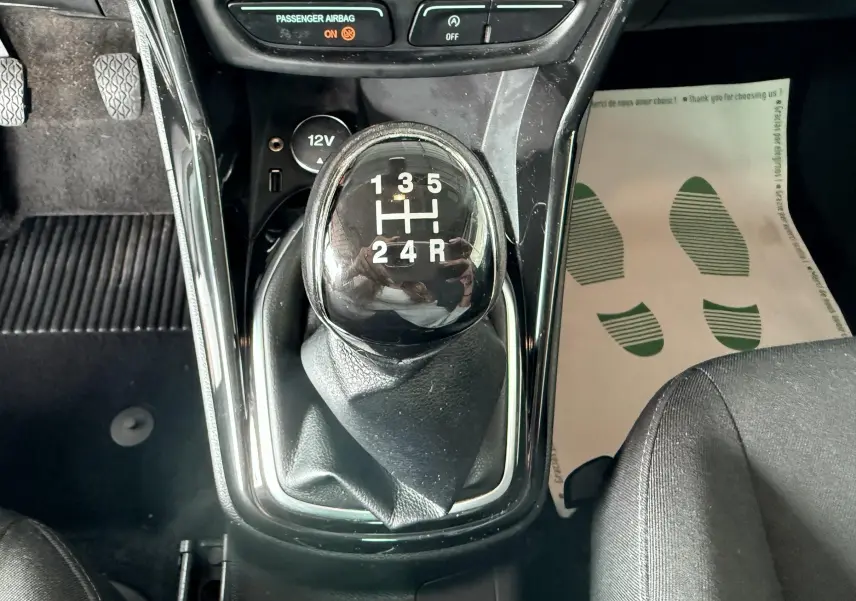 Le levier de vitesses manuel noir de la Ford B-MAX 2014, avec console centrale et tapis de sol visible côté passager.