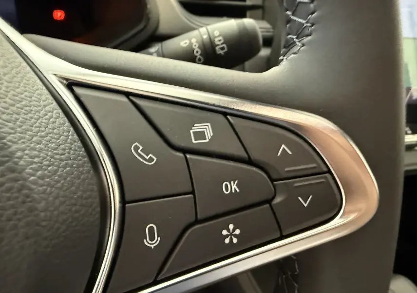 Gros plan sur les commandes au volant du Renault Captur gris cassiopée, avec boutons multifonctions et finition chrome.