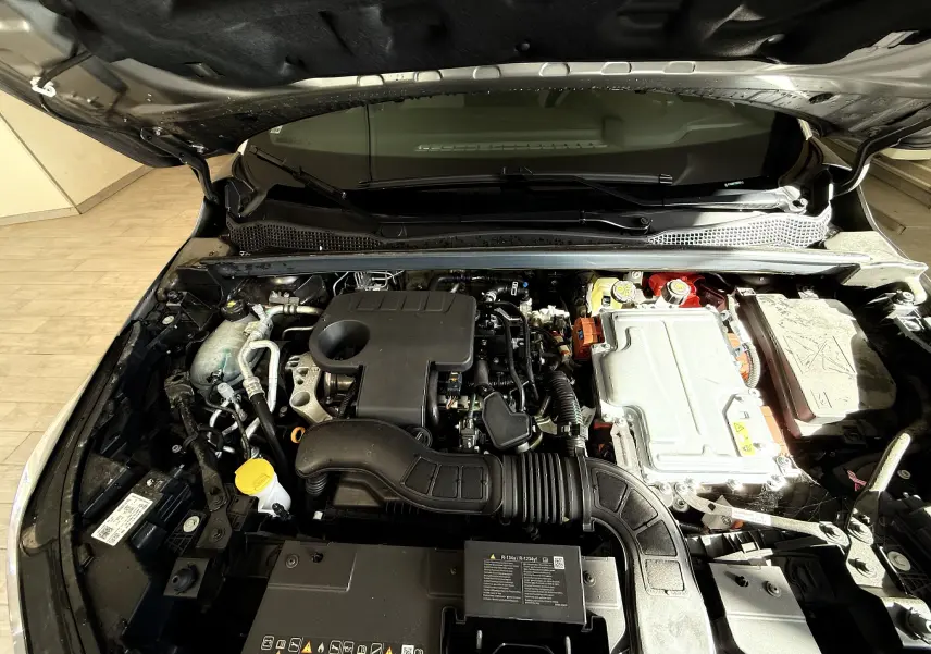 Vue plongeante sur le moteur hybride du Renault Captur 2025, montrant les composants mécaniques sous le capot ouvert.