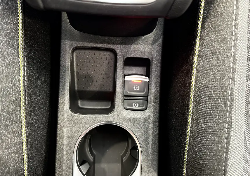 Gros plan sur la console centrale du Renault Captur gris cassiopée, mettant en valeur les commandes de frein à main et démarrage auto.