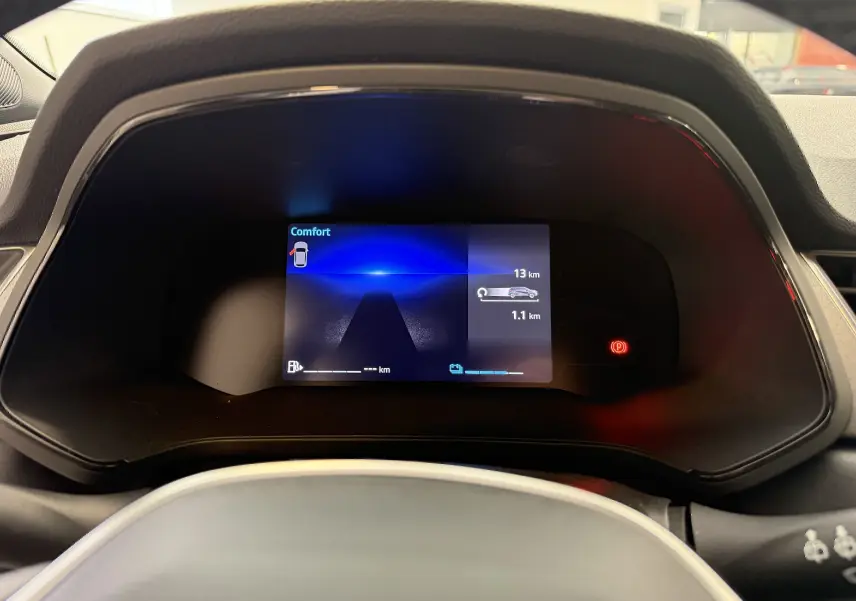 Affichage numérique du tableau de bord du Renault Captur 2025, avec indicateurs de distance et mode Confort visible.