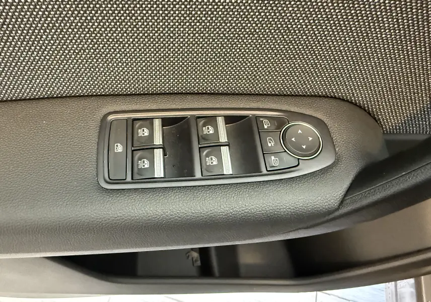 Panneau de commandes des vitres électriques et rétroviseurs sur la porte intérieure côté conducteur d'un Renault Captur gris 2025.