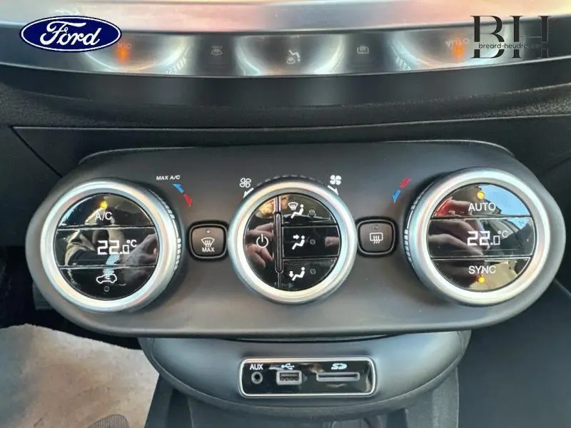 Panneau de commande de climatisation avec réglages digitaux à 22°C, boutons ronds et prises USB, AUX et SD.