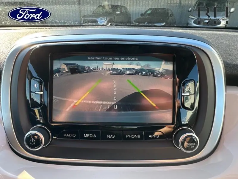 Écran tactile central montrant la caméra de recul d'une FIAT 500X argentée, vue arrière avec lignes de guidage colorées.