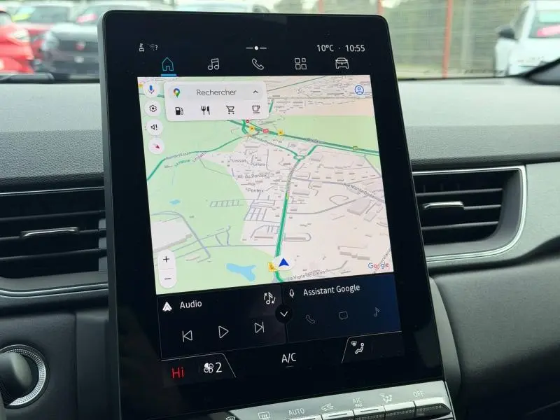 Vue intérieure centrée sur l'écran tactile du système multimédia du Renault Captur 2025, avec navigation Google Maps affichée.