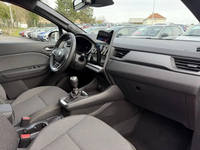 Vue intérieure côté conducteur du Renault Captur 2025 avec tableau de bord moderne et levier de vitesses manuel.