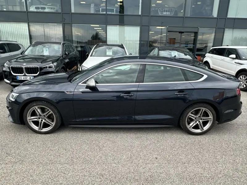 Profil droit d'une Audi A5 Sportback 2018 bleu lunaire métal avec jantes alliage cinq branches et vitres teintées.