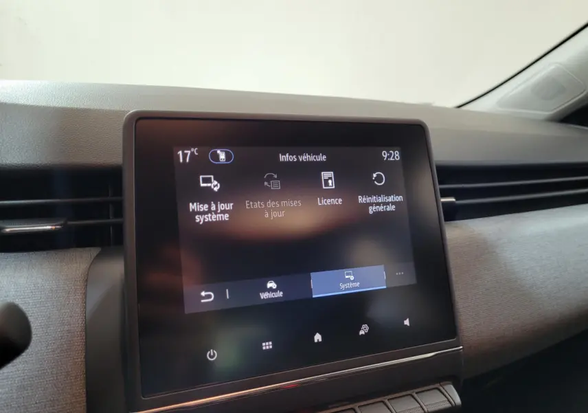 Écran tactile central affichant les réglages système dans l’habitacle d’une Renault Clio gris foncé, vue de face.