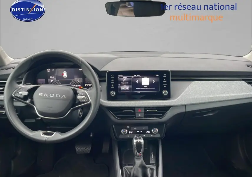 Vue intérieure frontale du tableau de bord noir et gris clair du Skoda Kamiq 2025 avec écran tactile et volant multifonction.