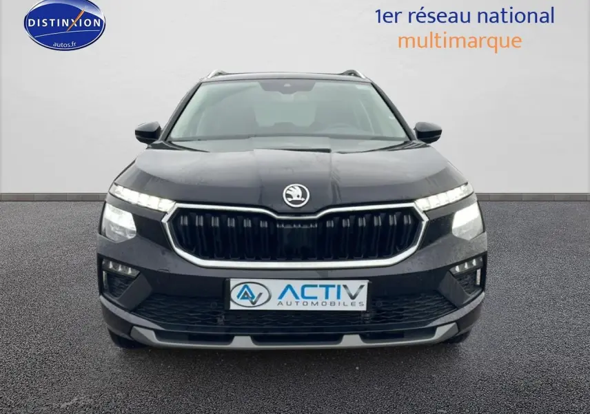 Vue frontale d'un Skoda Kamiq noir avec calandre chromée et feux LED allumés sur fond neutre.